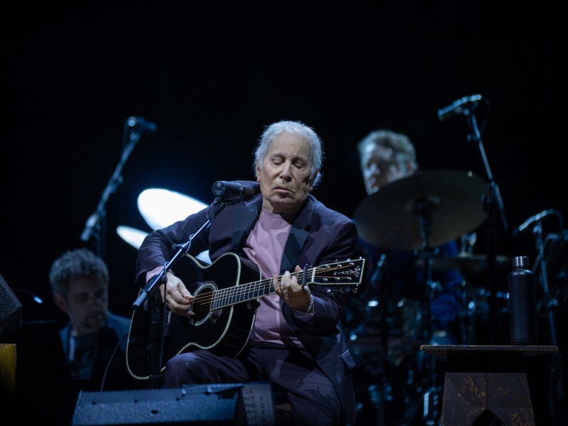 A man with a guitar on a stage.