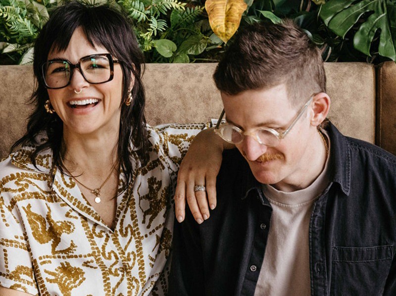 A couple sitting a couch and smiling